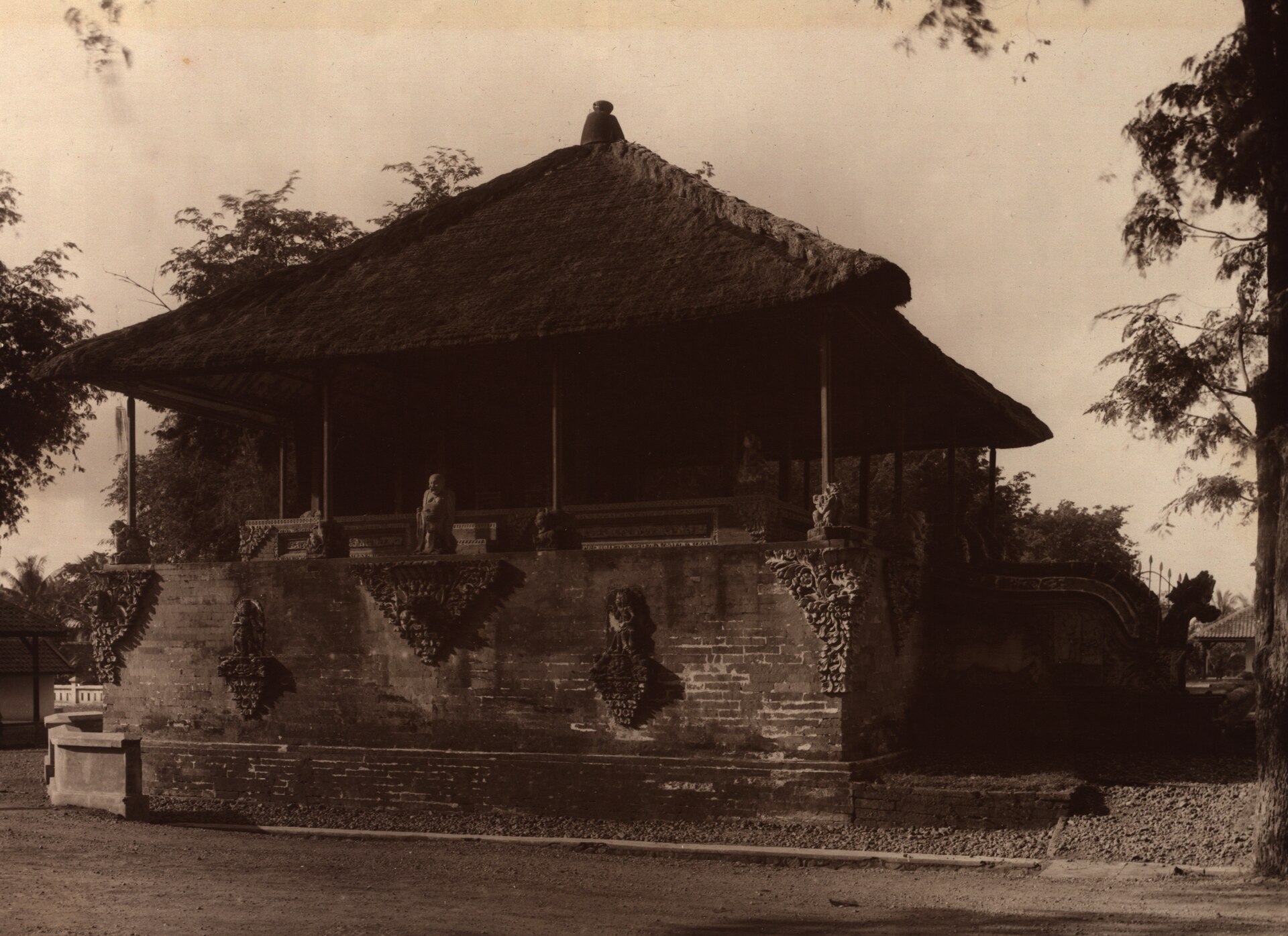 Foto sepia paviliun Kertha Gosa beratap ijuk di atas fondasi batu